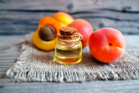 apricot-oil-from-apricot-kernels-glass-jar-fresh-ripe-apricots-old-wooden-table