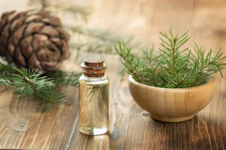 cedar-essential-oil-glass-bottle-soft-focus-wooden-background