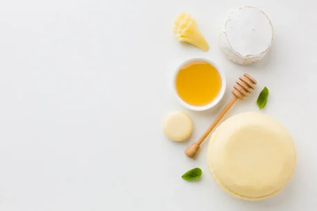 flat-lay-assortment-round-cheese-honey-with-copy-space
