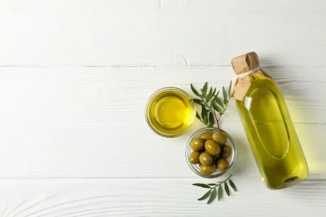 olives-bottle-bowl-with-olive-oil-wooden-top-view